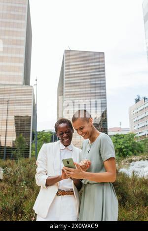 Image avec espace de copie de deux femmes d'affaires regardant heureux à un téléphone. Banque D'Images