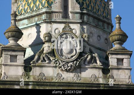 Gros plan d'un cartouche flanqué de putti au sommet de la Tour de l'horloge dans le centre de Brighton. Banque D'Images