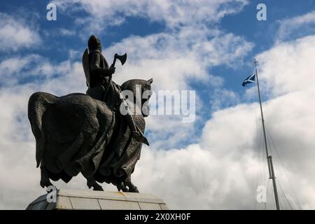 Statue en bronze montée du roi Robert Bruce d'Écosse sur le site du champ de bataille de Bannockburn en Écosse face au drapeau écossais de salage Banque D'Images