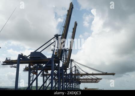 Construction métallique de grosses grues bleues à portique en position horizontale en attendant l'opération de cargaison des porte-conteneurs dans le port de Carthagène. Banque D'Images