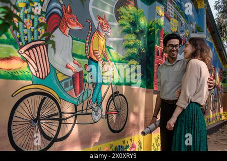 Dhaka, Bangladesh. 14 avril 2024. Un couple regarde un graffiti sur le mur de l'Institut des Beaux-Arts de l'Université de Dhaka. Des milliers de Bangladais célèbrent le premier jour du nouvel an bengali ou Pohela Boishakh, avec différents rassemblements colorés, des programmes culturels avec des danses traditionnelles et de la musique, cette année bengali a été introduite sous le régime de l'empereur Akbar pour faciliter la collecte des revenus au 16ème siècle. Crédit : SOPA images Limited/Alamy Live News Banque D'Images