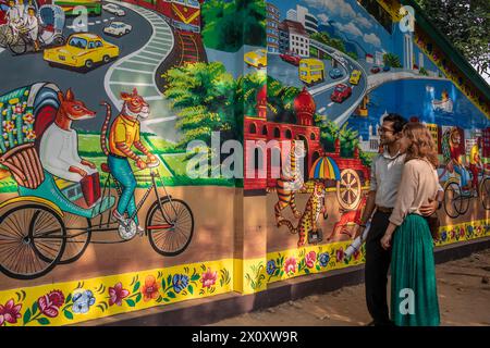 Un couple regarde un graffiti sur le mur de l'Institut des Beaux-Arts de l'Université de Dhaka. Des milliers de Bangladais célèbrent le premier jour du nouvel an bengali ou Pohela Boishakh, avec différents rassemblements colorés, des programmes culturels avec des danses traditionnelles et de la musique, cette année bengali a été introduite sous le régime de l'empereur Akbar pour faciliter la collecte des revenus au 16ème siècle. (Photo de Sazzad Hossain / SOPA images/SIPA USA) Banque D'Images