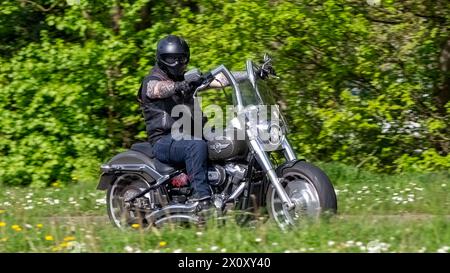 Milton Keynes, UK- 14 avril 2024 : homme conduisant une Harley Davidson 2018 flfbs Fatboy 114 moto sur une route britannique Banque D'Images