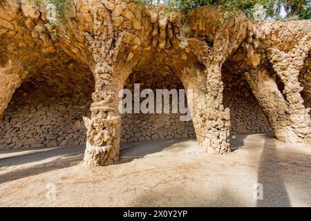 Viaduc dans la salle de blanchisserie Portico avec colonnes en maçonnerie avec mur de pierre en arrière-plan dans le Parc Guell, œuvre architecturale de Gaudi, journée ensoleillée à Ba Banque D'Images