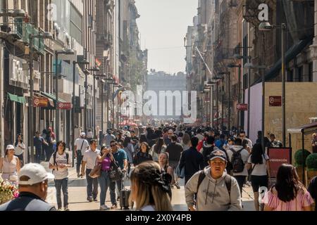 Les gens marchent sur Madero Street, une rue piétonne géographiquement et historiquement importante de Mexico. Madero Street à Mexico est une artère piétonne animée réputée pour son importance historique et son atmosphère vibrante. Bordée d'un mélange de bâtiments de l'époque coloniale, de boutiques et de cafés, elle offre aux visiteurs un aperçu du riche patrimoine culturel et de la vie urbaine contemporaine de la ville. Banque D'Images