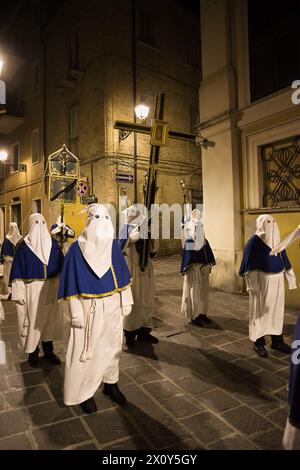 Les pénitents à capuche lors de la célèbre procession du vendredi Saint à Chieti (Italie) portent la croix à l'effigie de Jésus Banque D'Images