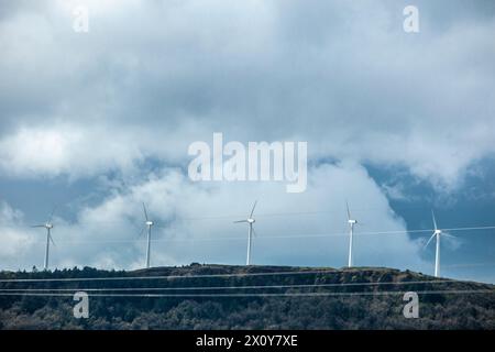 Éoliennes au sommet des collines. Lignes électriques au premier plan Banque D'Images