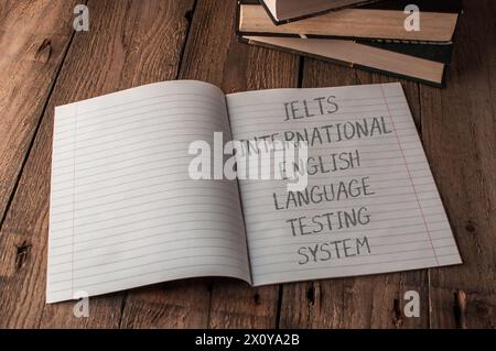 Un carnet de notes est ouvert à une page avec les mots IELTS International English Language Testing System' écrits dessus Banque D'Images