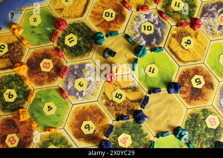 Mozyr, Biélorussie, 01 avril 2024 : une vue de dessus de jeu de société de catan de la disposition des figures de joueur sur le terrain de jeu. Rogue anti-héros dans le jeu. Banque D'Images