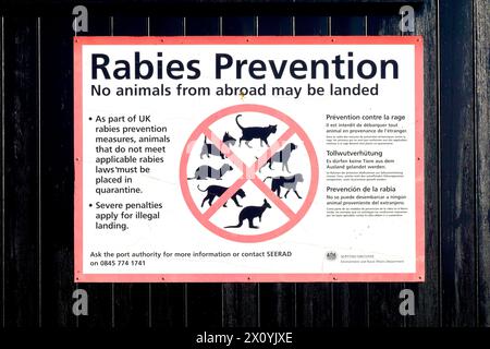 Gros plan d'un panneau attaché à un hangar peint dans le port d'Arbroath avertissant contre le débarquement d'animaux de l'étranger, qui fait partie des mesures de prévention de la rage au Royaume-Uni. Banque D'Images