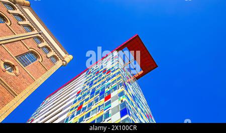 Dusseldorf (Medienhafen, Colorium), Allemagne - 1er mars. 2021 : gratte-ciel Colorium moderne coloré à côté du monument classé monument protégé PVH bâtiment en briques Banque D'Images