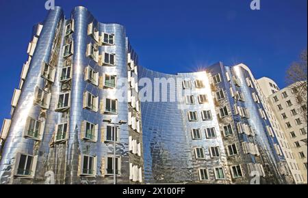 Düsseldorf (Medienhafen), Allemagne - 1er mars. 2021: Vue sur la maison Gehry avec argent brillant futuriste aluminium façade métallique contre bleu profond nuages Banque D'Images