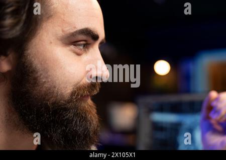 Gros plan d'un ingénieur joyeux parlant avec une IA sensible devenant superintelligent. Freelance INFORMATIQUE optimiste discutant avec l'intelligence artificielle consciente transcendant à la structure supérieure Banque D'Images