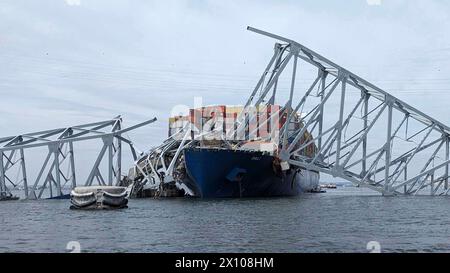 Dundalk (États-Unis d'Amérique). 26 mars 2024. Le porte-cargaison entremêlé MV Dali encastré dans les fermes d'acier du pont Francis Scott Key, effondré sur le chenal de Fort McHenry, au premier feu, le 26 mars 2024, près de Dundalk, dans le Maryland. Le pont a été heurté par le porte-conteneurs de 984 pieds tôt le matin du 26 mars et s'est effondré tuant six travailleurs et fermant le port de Baltimore. Crédit : Dave Adams/USACE/Alamy Live News Banque D'Images