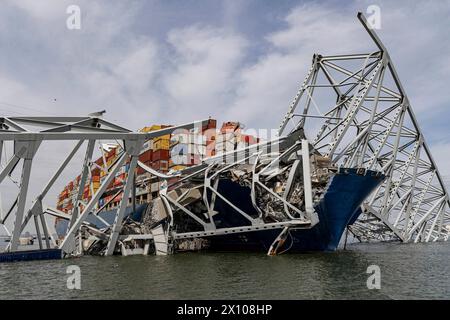 Dundalk (États-Unis d'Amérique). 26 mars 2024. Le porte-cargaison entremêlé MV Dali encastré dans les fermes d'acier du pont Francis Scott Key, effondré sur le chenal de Fort McHenry, au premier feu, le 26 mars 2024, près de Dundalk, dans le Maryland. Le pont a été heurté par le porte-conteneurs de 984 pieds tôt le matin du 26 mars et s'est effondré tuant six travailleurs et fermant le port de Baltimore. Crédit : Dave Adams/USACE/Alamy Live News Banque D'Images