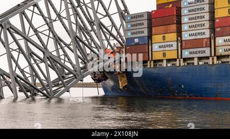 Dundalk (États-Unis d'Amérique). 26 mars 2024. Le porte-cargaison entremêlé MV Dali encastré dans les fermes d'acier du pont Francis Scott Key, effondré sur le chenal de Fort McHenry, au premier feu, le 26 mars 2024, près de Dundalk, dans le Maryland. Le pont a été heurté par le porte-conteneurs de 984 pieds tôt le matin du 26 mars et s'est effondré tuant six travailleurs et fermant le port de Baltimore. Crédit : Dave Adams/USACE/Alamy Live News Banque D'Images