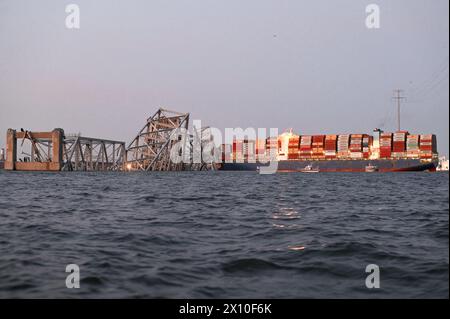 Dundalk (États-Unis d'Amérique). 26 mars 2024. Le porte-cargaison entremêlé MV Dali encastré dans les fermes en acier du pont Francis Scott Key, qui bloque le chenal de Fort McHenry, le 26 mars 2024, près de Dundalk, Maryland. Le pont a été heurté par le porte-conteneurs de 984 pieds le 26 mars et s'est effondré tuant six travailleurs. Crédit : PO3 Carmen Caver/US Coast Guard/Alamy Live News Banque D'Images