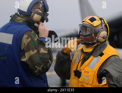 L'Adjudant-chef LaTonya Wallace, à droite, parle avec l'aviateur Recruit Ryan Elkins, compagnon de bateau d'aviation (maniement), pendant les opérations de vol à bord du navire d'assaut amphibie déployé en avant USS Essex. Essex est en cours pour sa patrouille annuelle de printemps dans toute la région du Pacifique Ouest, CA. 25 janvier 2004 (la date par métadonnées est 2010) Banque D'Images