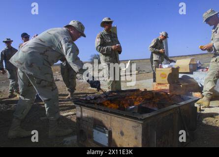 Soldats de la compagnie C, 2e bataillon, 124e régiment d'infanterie, avec l'équipe de combat de la 53e brigade d'infanterie, profitant d'un barbecue dans leur zone de vie après leur arrivée en Asie du Sud-Ouest, avant de déménager en Irak en 2003. Banque D'Images