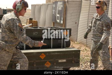 Le Pvt Jessie W. Grigsby et le SPC Jay Gage réparateurs de systèmes d'armement/électrique/avionique pour la compagnie Bravo, 209e bataillon de soutien à l'aviation, 25e brigade d'aviation de combat, à la base opérationnelle de contingence Speicher déplacent les armes qui sont utilisées au point de ravitaillement en carburant (FARP) CA. 1er mai 2007 (date par métadonnées) Banque D'Images