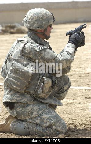 Le sergent d'état-major Ryan Rezentes, un sous-officier du détachement de sécurité personnelle du quartier général et de la compagnie de quartier général, 4e brigade de combat, 1re division d'infanterie de Brentwood, Calif, regarde sa cible après avoir dépensé toutes les munitions pour son pistolet de 9 mm à une portée dans le district Rashid de Bagdad vers. 23 avril 2004 Banque D'Images