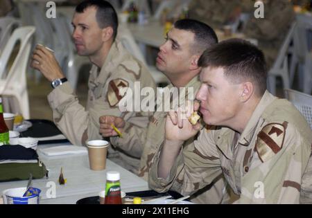 Les troupes de l'équipe de combat de la 4e brigade, de la 1re division de cavalerie se détendent, profitant de la camaraderie lors d'un petit déjeuner de prière au camp Cooke tente chow Hall le 6 mai 2004. Le petit déjeuner de prière a eu lieu le premier Thurseday de mai en conjonction avec la Journée nationale de prière. Banque D'Images