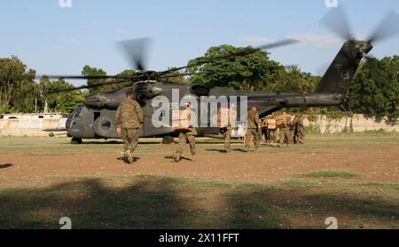 Les Marines du bataillon de logistique de combat 22, 22e unité expéditionnaire des Marines, déchargent des repas prêts-à-manger d'un hélicoptère MH-53E Sea Dragon de la Marine du 14e escadron de lutte contre les mines d'hélicoptères, à petit Goave, Haïti, le 24 janvier 2010. En réponse à un tremblement de terre dévastateur, qui a frappé le pays d’Haïti, les Marines et les marins de la 22e MEU ont commencé à livrer des fournitures de secours et à fournir une aide médicale à l’appui de l’opération réponse unifiée, le 19 janvier. Banque D'Images