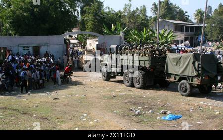 Les Haïtiens regardent les Marines de la Compagnie indienne, de l'équipe de débarquement du bataillon, du 3e bataillon, du 2e régiment de Marines, de la 22e unité expéditionnaire des Marines, quitter petit Goave, Haïti, dans un convoi, le 24 janvier, 2010. à la suite d'un tremblement de terre dévastateur qui a frappé Haïti, les Marines et les marins de la 22e MEU ont commencé à acheminer des secours et à fournir une aide médicale à l'appui de l'opération réponse unifiée, le 19 janvier. Banque D'Images