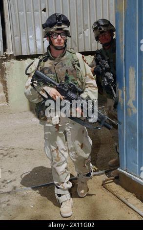 Le SPC Jeff Newberry patrouille dans les rues de Mossoul. En janvier, Newberry a sauvé la vie de deux soldats et d’un policier irakien de la noyade lorsque leur bateau a chaviré dans le Tigre CA. 14 juillet 2004 Banque D'Images