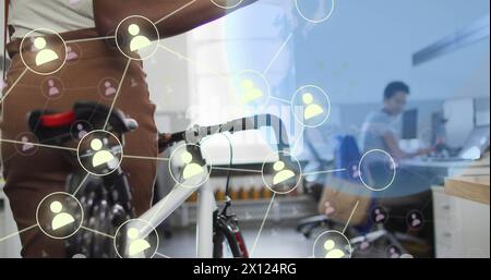 Image du globe et des icônes de médias sociaux sur divers hommes d'affaires avec vélo dans le bureau Banque D'Images