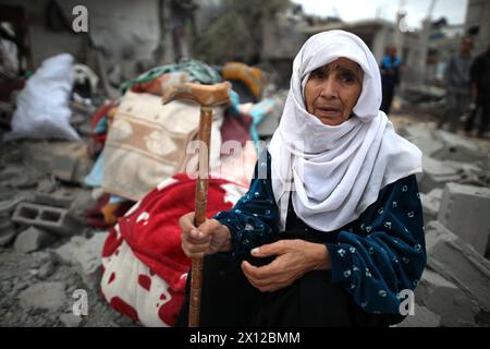 Pékin, Chine. 15 avril 2024. Une femme âgée est assise sur les débris après les frappes aériennes israéliennes dans le camp de réfugiés d’Al-Maghazi dans le centre de la bande de Gaza, le 13 avril 2024. Crédit : Xinhua/Alamy Live News Banque D'Images