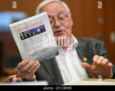 15 avril 2024, Hesse, Francfort-sur-le-main : Horst R. Schmidt, ancien secrétaire général de la DFB, tient le livre « Overtime » de l'ancien président de la FIFA, Sepp Blatter, dans la salle d'audience du tribunal régional. Le parquet accuse trois anciens fonctionnaires de la DFB d'évasion fiscale. Photo : Arne Dedert/dpa-Pool/dpa Banque D'Images