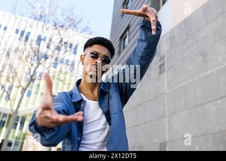 Jeune homme confiant effectuant un geste à l'extérieur regardant la caméra. Banque D'Images