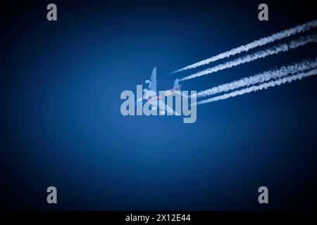 Flugverkehr - Chemtrails Ein Verkehrsflugzeug der Fluggesellschaft Emirates hinterlässt am strahlend blauen Himmel Kondensstreifen. 20230616MIC0017 *** trafic aérien Chemtrails un avion de ligne Emirates laisse des traînées dans le ciel bleu vif 20230616MIC0017 Banque D'Images