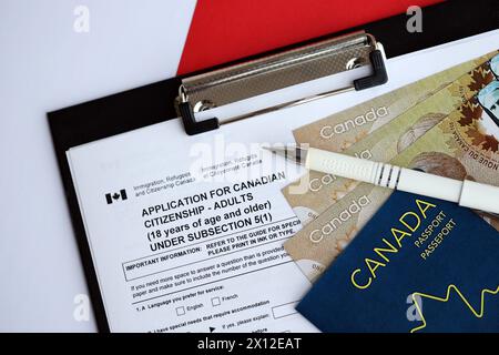 Demande de citoyenneté canadienne pour adultes sur la table avec stylo, passeport et billets d'un dollar gros plan Banque D'Images