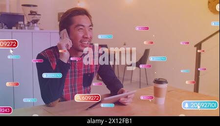 Image d'icônes de médias sur homme asiatique heureux à l'aide d'un smartphone Banque D'Images