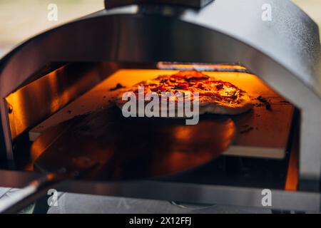 Cuisson de pizza dans un four à pizza extérieur Banque D'Images
