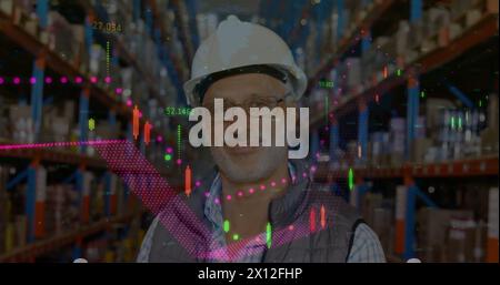 Image de graphiques financiers sur l'heureux employé d'entrepôt masculin caucasien senior Banque D'Images