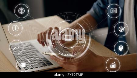 Image d'icônes d'éducation tombant au-dessus d'une personne utilisant un ordinateur portable Banque D'Images