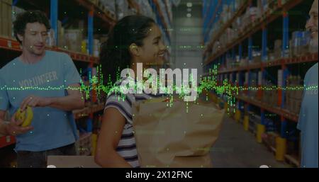 Image de graphiques financiers sur des ouvriers d'entrepôt heureux et diversifiés Banque D'Images