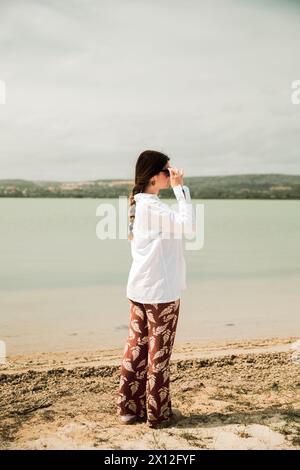 Fille dans une chemise blanche et des lunettes de soleil à côté d'un joli lac en France Banque D'Images