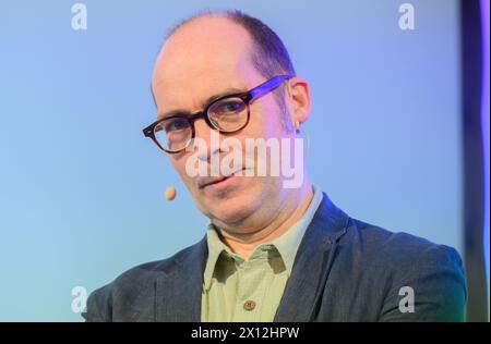 Hanovre, Allemagne. 15 avril 2024. Ingo Siegner, auteur de livres pour enfants, prend la parole lors d'une lecture pour les enfants de l'école primaire au Künstlerhaus Hannover. Pour marquer le 70e anniversaire de la Friedrich-Bödecker-Kreis Niedersachsen (FBK), 70 lectures ont été organisées par des auteurs pour des garderies et des écoles de basse-Saxe. L'auteur de livres pour enfants Ingo Siegner a lu des livres de Drache-Kokosnuss. Crédit : Julian Stratenschulte/dpa/Alamy Live News Banque D'Images