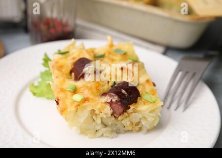 Savoureuse casserole à saucisses avec oignons verts servis sur table, gros plan Banque D'Images