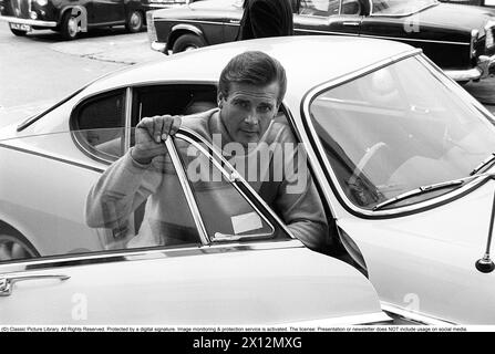 Sir Roger Moore , 1927-2017 ans pendant le tournage de la série télévisée The Saint, posant avec une Volvo P1800. Une voiture de sport fabriquée par Volvo Cars dont la production commencera en 1961 et se terminera en 1973. Le style a été dessiné par le designer suédois Pelle Pettersson. La voiture a été présentée au salon de l'automobile de Genève en 1961. Le modèle P1800 a vendu 47492 voitures. Le P1800 est devenu largement connu lorsqu'il était conduit par l'acteur Roger Moore, futur James Bond, dans le rôle de Simon Templar dans la série télévisée The Saint. The Saint a couru à partir de 1962 pour six saisons et 118 épisodes. 1966 Sir Roger Moore , 1927-2017 pendant le tournage de la série télévisée The SAI Banque D'Images