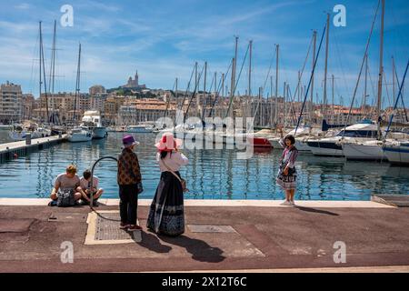 Marseille, France. 13 avril 2024. Touristes asiatiques se photographiant avec la femme de chambre en arrière-plan sur le vieux-port de Marseille, France, 13 avril 2024. Photo de Laurent Coust/ABACAPRESS.COM crédit : Abaca Press/Alamy Live News Banque D'Images