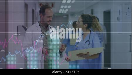 Image des graphiques, les chiffres changeant sur le médecin caucasien debout et discutant des rapports des patients Banque D'Images