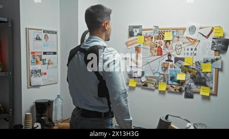 Homme hispanique examine le conseil de preuve du crime dans le département de police, suggérant un travail de détective. Banque D'Images