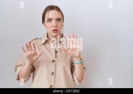 Jeune femme caucasienne portant une chemise décontractée éloignant les mains des paumes montrant le refus et le déni avec une expression effrayée et dégoûtante. arrêtez et interdites Banque D'Images