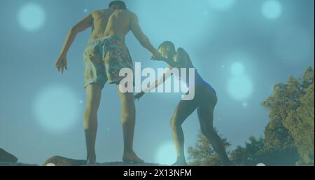 Image de taches brillantes sur un couple divers tenant la main Banque D'Images