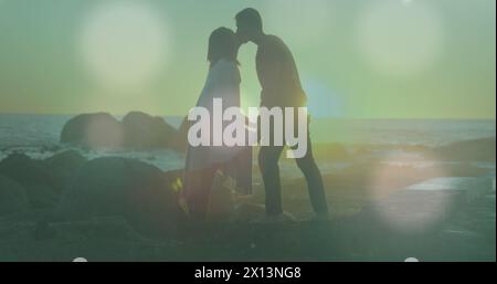 Image de taches brillantes au-dessus de divers couples s'embrassant Banque D'Images
